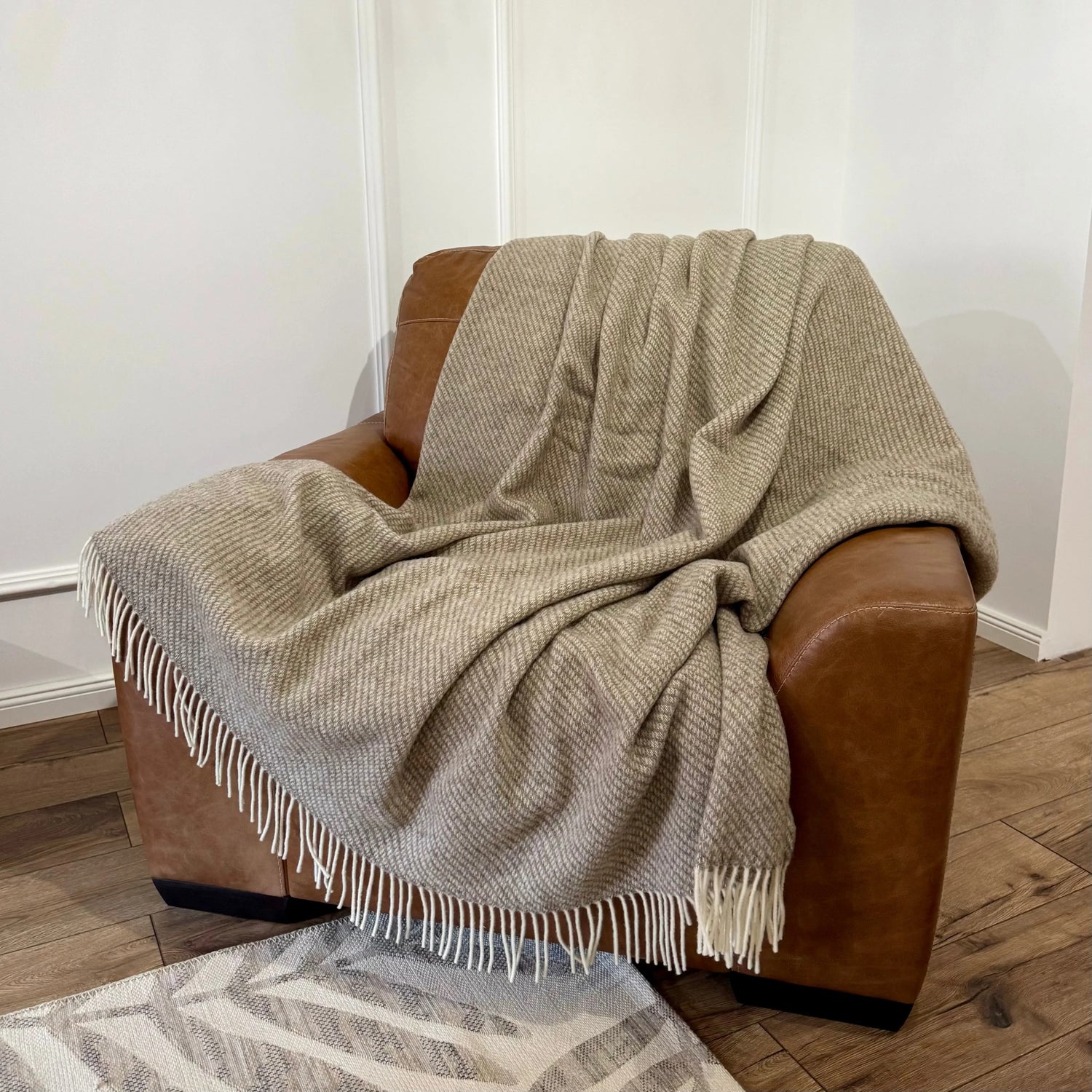 Pătură mare din lână naturală Zelandia, plasată pe fotoliu, perfectă pentru pat dublu
