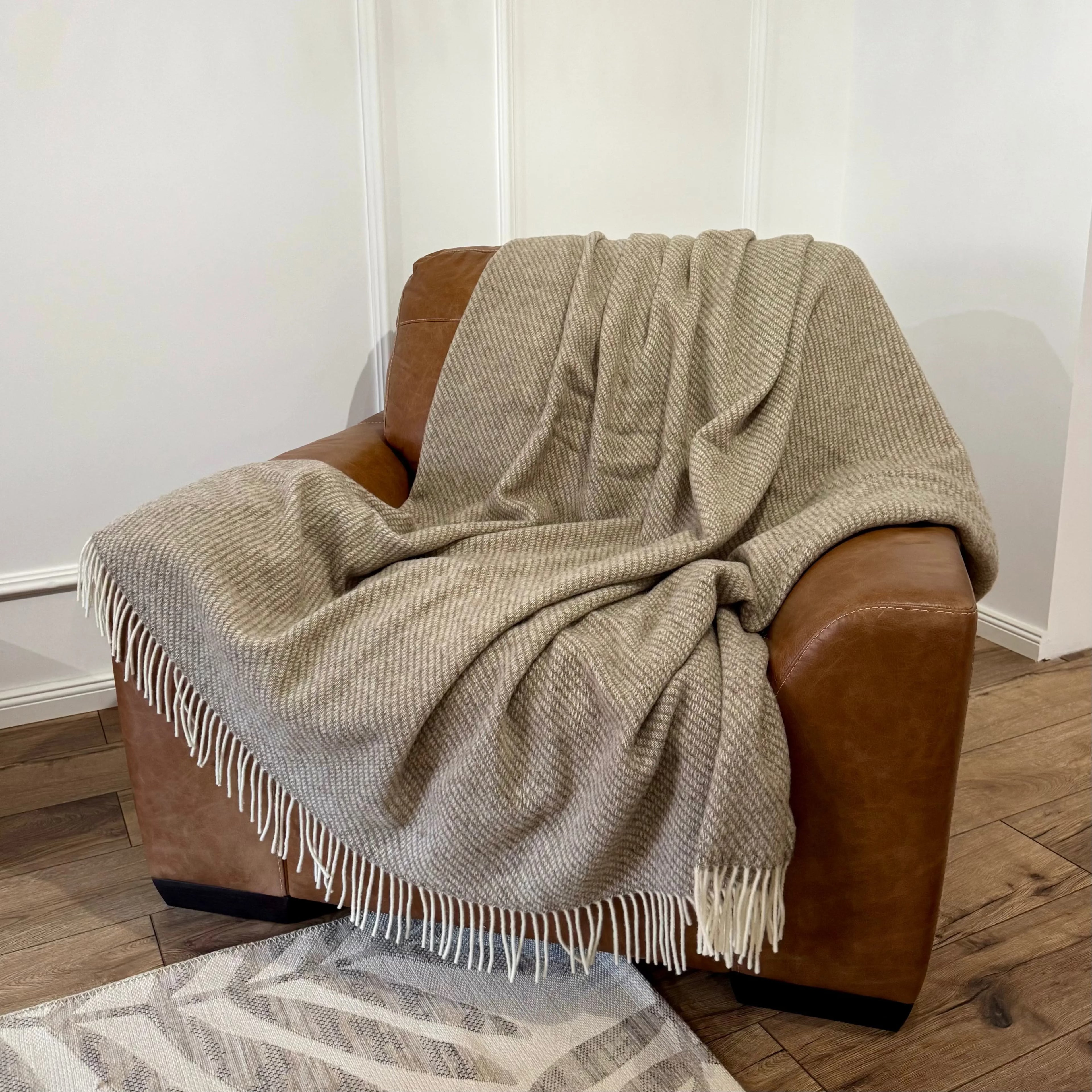 Pătură mare din lână naturală Zelandia, plasată pe fotoliu, perfectă pentru pat dublu