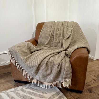 Pătură mare din lână naturală Zelandia, plasată pe fotoliu, perfectă pentru pat dublu